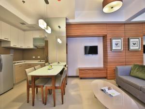 马尼拉Valero Grand Suites by Swiss-Belhotel的厨房以及带桌子和沙发的客厅。
