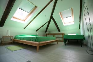 都灵玛利亚别墅的一间卧室设有两张绿色的床和两个窗户。