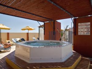 圣保罗湾城卡尼富尔酒店的庭院内的热水浴池和遮阳伞