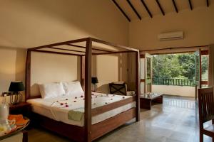 哈伯勒内塞瓦纳加马乡村民宿的一间卧室设有一张天蓬床和一个阳台