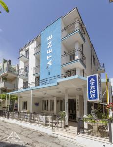 里乔内Atene Albergo Riccione的蓝色的建筑,前面有标志