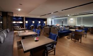 台南台南晶英酒店 的一间带桌子和蓝色椅子的餐厅以及一间带桌椅的餐厅