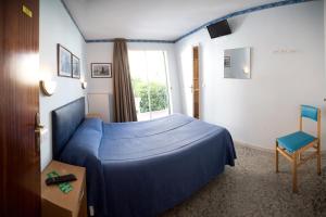 滨海托萨赫斯塔勒特酒店的一间卧室配有蓝色的床和椅子