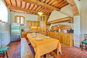 因普鲁内塔Casa Scopeti by PosarelliVillas的厨房配有长桌和冰箱