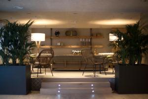 塞维利亚塞维利亚泽尼特酒店的客厅配有沙发、椅子和植物
