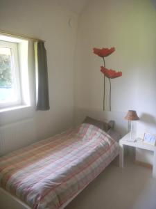 隆德泽尔Verreveld的卧室配有一张挂着红花的床。