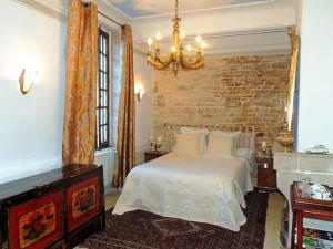 克卢尼Maison Romane 1136的一间卧室设有一张床和砖墙
