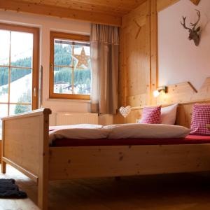 贝旺TiroLiving的卧室在窗户前配有木床
