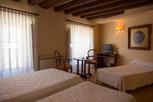 阿尔玛桑Tirso de Molina的一间卧室配有两张床、一张桌子和一台电视。