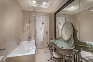 巴黎杜克圣西蒙酒店的带浴缸的浴室和2名穿着白色服装的男士