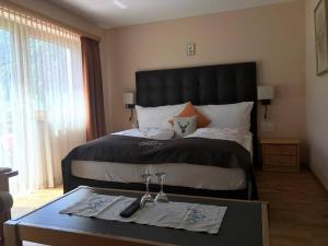 策尔内茨塞尔瓦比萨店酒店的一间卧室配有一张大床和一张桌子,桌子上放着眼镜