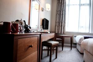 伦敦富勒疯帽子酒店的酒店客房配有书桌和镜子