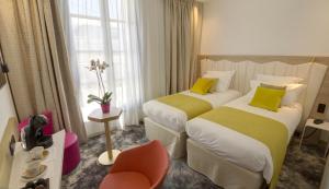 蒙彼利埃圣罗奇喜剧贝斯特韦斯特优质酒店的酒店客房,配有两张床和椅子