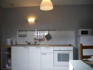 康布雷Apt 8 du Temple HyperCentre & Parking的厨房配有白色橱柜和白色冰箱。