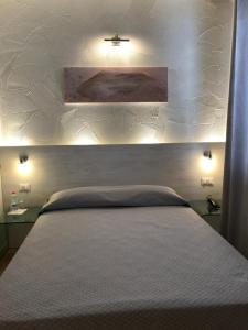 雷焦艾米利亚诺瓦酒店的一间卧室配有一张带白色床头板的大床