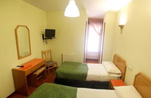 布尔戈斯阿尔兰松旅馆的酒店客房,设有两张床和镜子