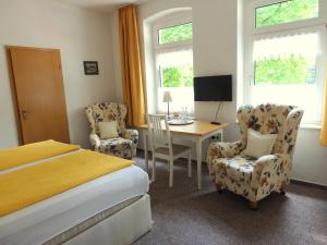 霍恩-巴特迈恩贝格科内酒店的卧室配有一张床、一张桌子和椅子
