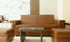 阿姆利则Treebo Trend Dee Intercontinental Amritsar的客厅配有棕色沙发和桌子