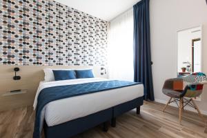 米兰伊索拉公寓式酒店的一间卧室配有一张带蓝色毯子和墙壁的床。