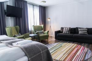 基律纳SPiS旅馆的酒店客房配有一张床、一张沙发和椅子。