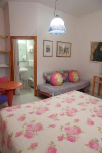 蓬泰代拉伊尔法尔盖托酒店的一间卧室配有一张床和一张带粉红色枕头的沙发。