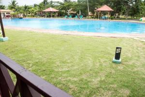 圣多美Praia Accommodation的围栏旁的草地上带标志的游泳池