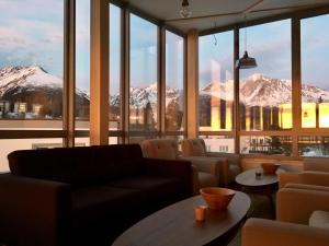 什特尔布斯凯普莱索维拉伯勒酒店的一间配备有沙发及桌子的客房,拥有积雪覆盖的山脉。