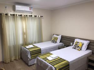 Telêmaco BorbaOpen Hotel的一间设有两张床和空调的房间