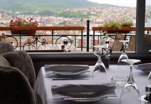 普里什蒂纳比诺丘酒店的一张带酒杯的桌子,享有城市美景