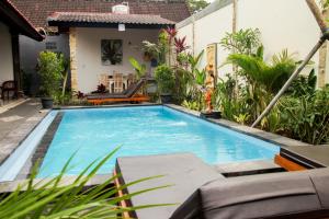坎古Nyoman Guesthouse Berawa Canggu的一座房子的院子内的游泳池