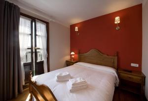 Elgeta马尔德乡村民宿的卧室配有白色的床铺和红色的墙壁