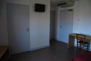 勒泊桑法兰西酒店的一间设有书桌的房间和一扇带电视的门