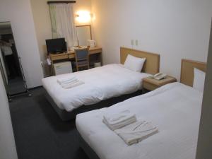 仙台绿井酒店的酒店客房配有两张床和一张书桌