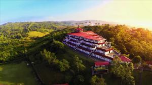 Lumban卡利亚拉俱乐部度假酒店的一座大建筑,在山坡上设有红色屋顶