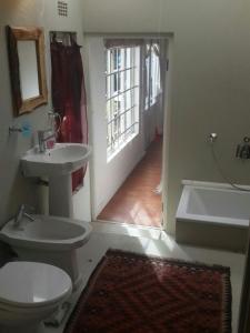 开普敦Dancers' Cottages的浴室配有卫生间、盥洗盆和浴缸。