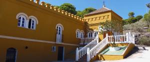 博尔诺斯Hostal La Parada的前面有白色楼梯的黄色建筑