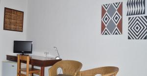 基加利勒加尼酒店的配有桌椅和电视的客房
