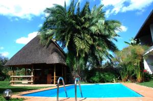基加利勒加尼酒店的棕榈树和游泳池的度假村