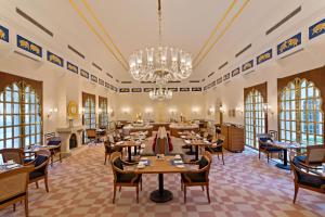 钱德加尔The Oberoi Sukhvilas Spa Resort, New Chandigarh的一间带桌椅和吊灯的餐厅