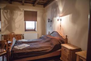 CsarodaCsaronda Vendegház的一间卧室配有一张床、一张桌子和一个窗户。