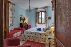 基安蒂盖奥勒La Loggetta - Chianti apartments的卧室配有床、椅子和窗户。