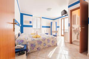 科廖Albergo Belvedere的蓝色和白色的卧室设有一张床和一间浴室