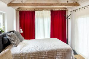 Sankt OlofLitet Gästhus i Sankt Olof的一间卧室配有红色和白色的窗帘和床