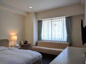 横须贺市横须贺港酒店的酒店客房设有床、沙发和窗户。