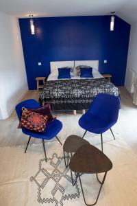 尼伊圣乔治道斯努伊茨旅馆的一间卧室配有一张带蓝色墙壁和蓝色椅子的床