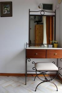 斯塔菲罗斯Olympion Apartments的浴室设有梳妆台、镜子和椅子