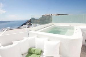 菲罗斯特法尼倾城套房酒店的阳台上的按摩浴缸,享有海景