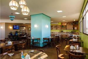 维多利亚-达孔基斯塔Livramento Palace Hotel的一间带桌椅和蓝色墙壁的餐厅