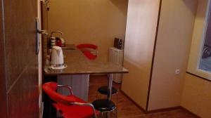 第比利斯Apartment in the heart of Old Tbilisi的一个带柜台和两张红色椅子的小厨房