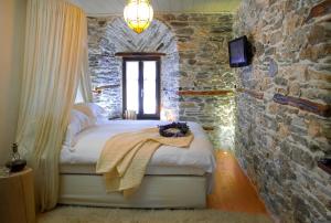 莫雷逊山之秘旅馆的卧室配有一张石墙床